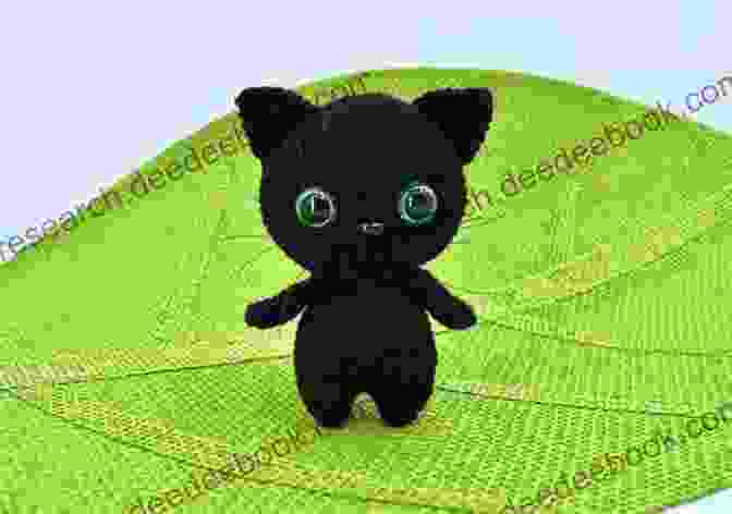 A Crocheted Black Cat With Green Eyes And A Black Yarn Tail Adorable Halloween Crochet Tutorials: Cute Halloween Patterns And Instructions